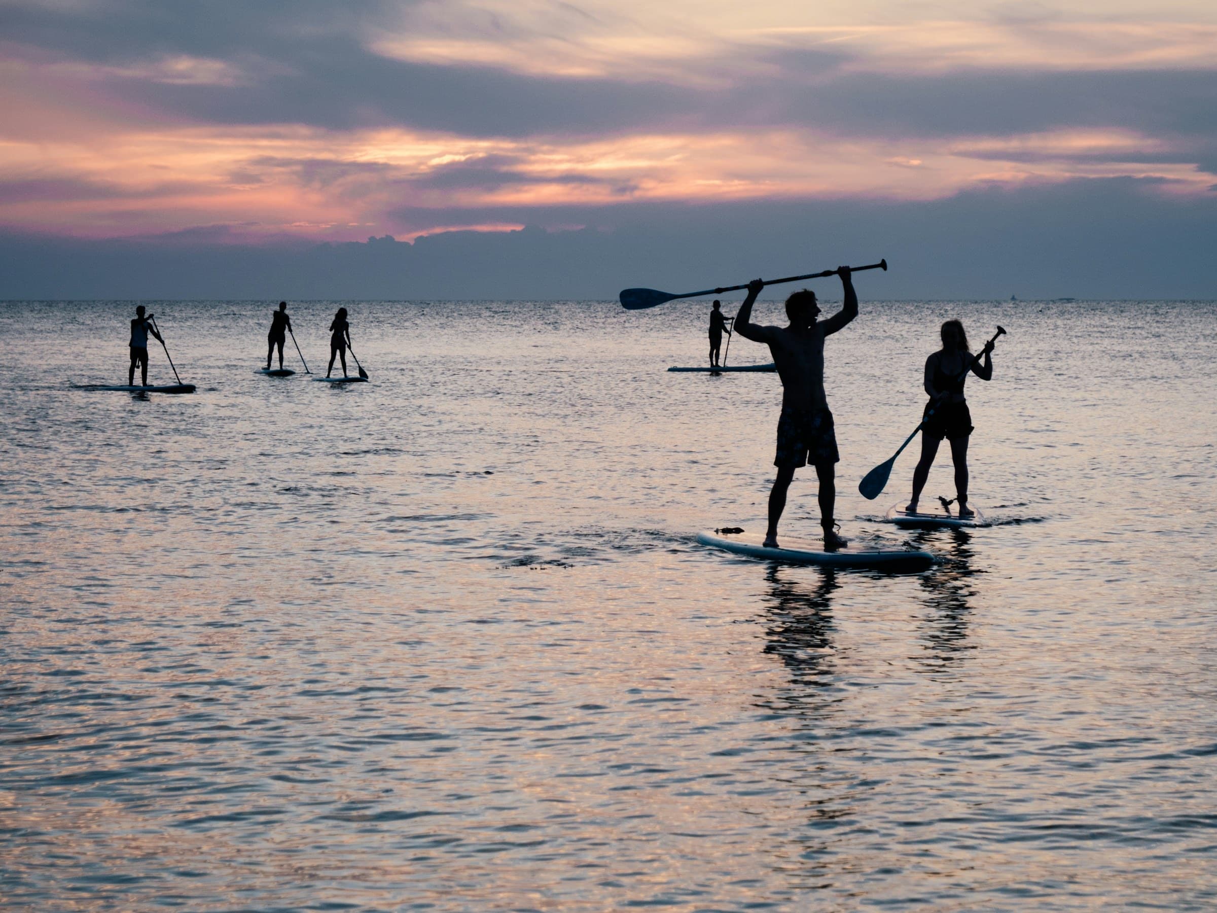 Gruppe beim Stand Up Paddling im Abendlicht