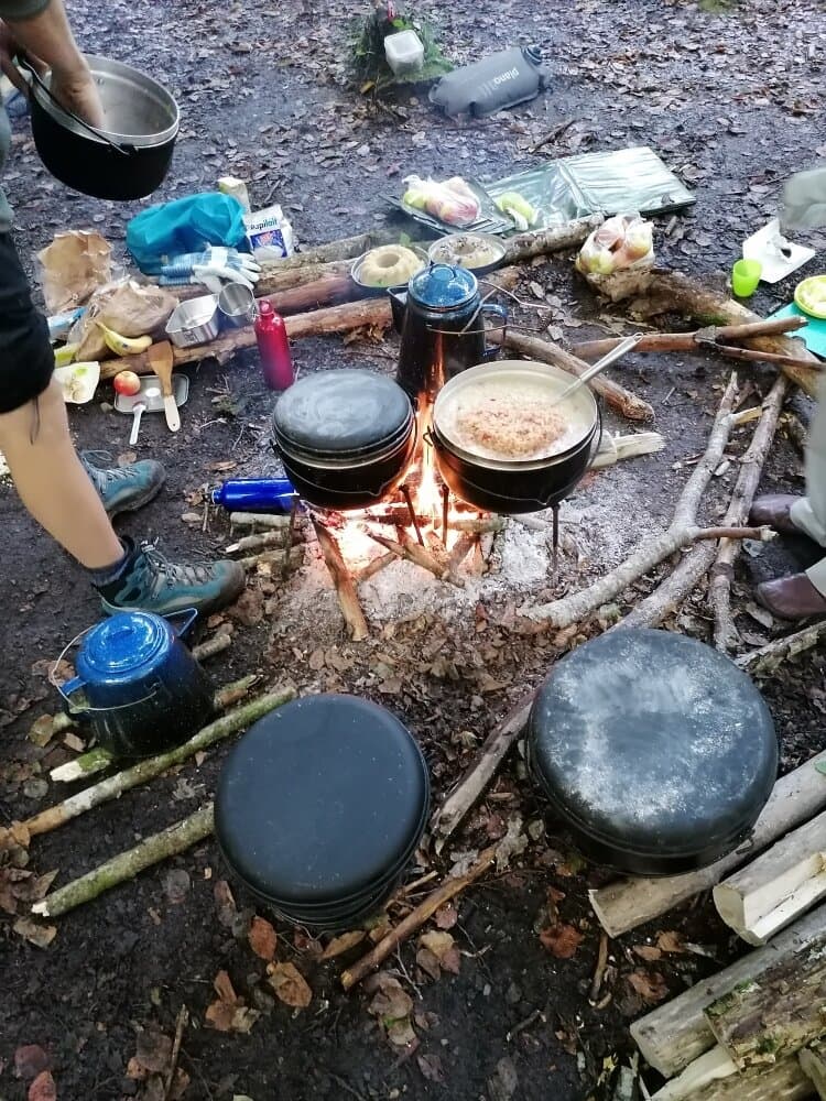 Töpfe und Kessel über dem offenen Feuer im Wald